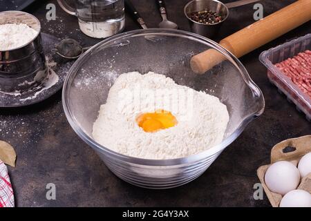 Ingredienti per torte di maet o gnocchi su un vassoio di metallo impasto, farina e trito Foto Stock