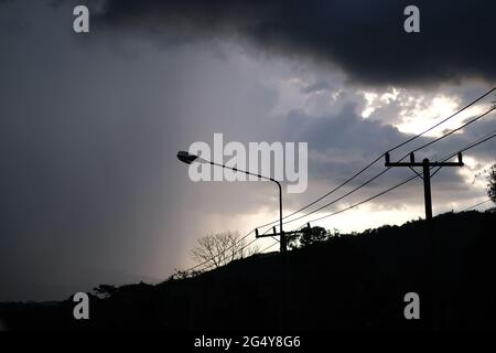 Pioggia pesante in arrivo su montagne, strade e linee di trasmissione elettrica in una remota regione montana della Thailandia del Sud Foto Stock