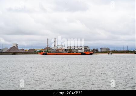 Cave di inerti Industries sull'isola di Grain con chiatta ormeggiata al molo nell'estuario del Tamigi, Kent, Inghilterra. Foto Stock