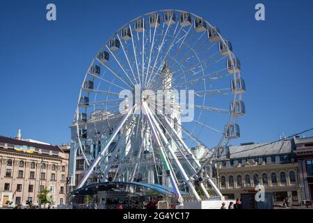 Kiev, Ucraina - 10 maggio 2021. Ruota panoramica su piazza Kontraktova a Kiev, Ucraina. Ruota panoramica con cabine chiuse. Persone che camminano sulla piazza centrale. Foto Stock