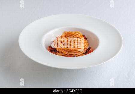 Ciotola di Spaghetti con pomodori ciliegini e basilico grattugiato Foto Stock