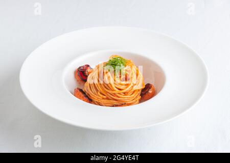 Ciotola di Spaghetti con pomodori ciliegini e basilico grattugiato Foto Stock