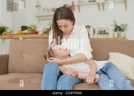 La mamma ascolta i problemi della figlia piccola, i suoi abbracci e la conforta. Madre premurosa che sostiene la figlia sconvolta, che parla, che discute i problemi, fidata f Foto Stock