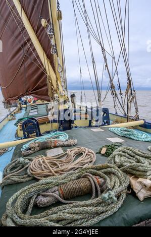 Varie corde disposte sulla copertura sul ponte della storica chiatta a vela 'Edith May' durante un viaggio nell'estuario del Tamigi, Kent, Inghilterra. Foto Stock