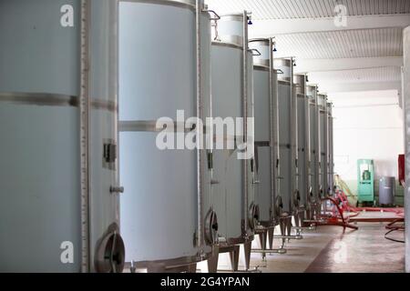 Serbatoi industriali in metallo per il vino in un impianto per la produzione di bevande alcoliche. Foto Stock