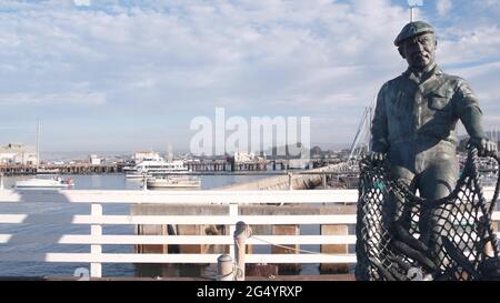 Monterey, California USA -9 dicembre 2020 Old Fisherman Wharf vicino Cannery Row. Uomo operaio figura, pesce in rete, statua di bronzo di Jesse Corsaut, monumento sc Foto Stock