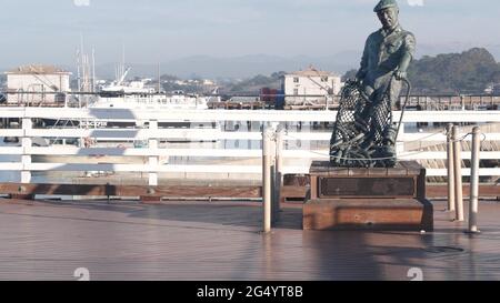 Monterey, California USA -9 dicembre 2020 Old Fisherman Wharf vicino Cannery Row. Uomo operaio figura, pesce in rete, statua di bronzo di Jesse Corsaut, monumento sc Foto Stock