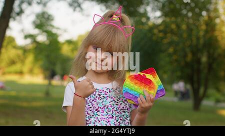 Bambini ragazza capretto che tiene pop esso giocattoli sensoriali, fidgeting trendy anti-stress silicone bolle gioco Foto Stock