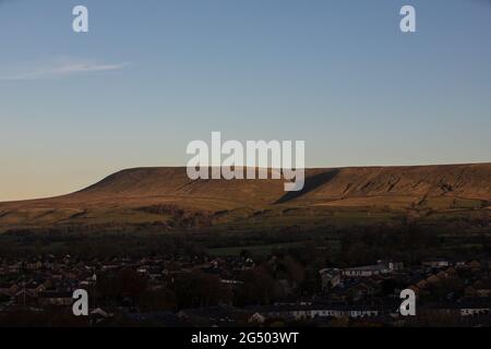 Vista sulla valle del ribble e sulla collina di pendle. Punto di osservazione dal castello Clitheroe con la collina che splende nella luce della sera Foto Stock