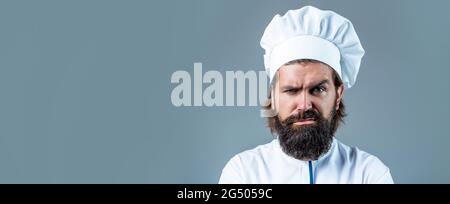 Ritratto di un cuoco serio. Cuoco, cuochi o panettiere con bearded. Cuochi maschi bearded isolati. Cuoci cappello. Cuoco maschile sicuro in uniforme bianca Foto Stock