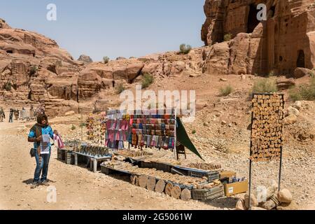 Un negoziante locale che vende souvenir nel suo negozio all'aperto all'interno del Petra in Giordania Foto Stock