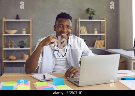 Ritratto di giovane sorridente allegro uomo d'affari afro-americano al portatile Foto Stock