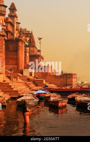 VARANASI, UTTAR PRADESH, INDIA - FEBBRAIO 02 2021: L'uomo indiano che bagna e fa offerte al fiume Gange a Varanasi, Uttar Pradesh, India Foto Stock