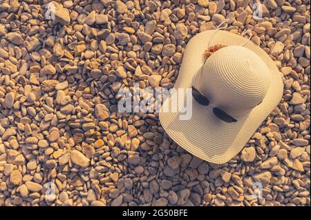 Cappello di sole e occhiali da sole su un tema di vacanza di Rocky Beach. Foto Stock
