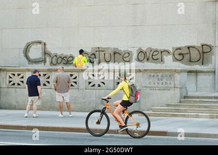 Ottawa, Canada. 24 Giugno 2021. Pulizia personale rimozione Pro ambiente graffiti sulla costruzione della Banca del Canada nella capitale canadese. Un messaggio per scegliere la natura rispetto al PIL prima che sia tardi potrebbe essere visto in tutti i façade. Sia la Banca del Canada che gli edifici della Corte Suprema sono stati bersaglio dai vandali durante la notte. Credit: Meanderingemu/Alamy Live News Foto Stock