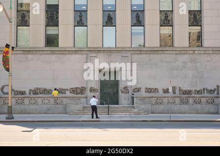 Ottawa, Canada. 24 Giugno 2021. Pulizia personale rimozione Pro ambiente graffiti sulla costruzione della Banca del Canada nella capitale canadese. Un messaggio per scegliere la natura rispetto al PIL prima che sia tardi potrebbe essere visto in tutti i façade. Sia la Banca del Canada che gli edifici della Corte Suprema sono stati bersaglio dai vandali durante la notte. Credit: Meanderingemu/Alamy Live News Foto Stock