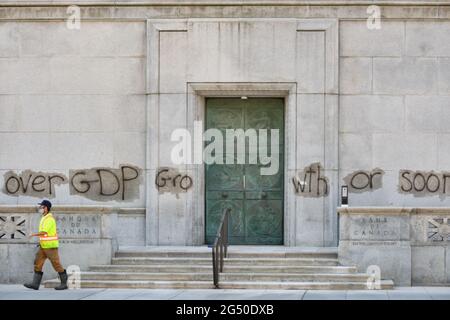 Ottawa, Canada. 24 Giugno 2021. Pulizia personale rimozione Pro ambiente graffiti sulla costruzione della Banca del Canada nella capitale canadese. Un messaggio per scegliere la natura rispetto al PIL prima che sia tardi potrebbe essere visto in tutti i façade. Sia la Banca del Canada che gli edifici della Corte Suprema sono stati bersaglio dai vandali durante la notte. Credit: Meanderingemu/Alamy Live News Foto Stock