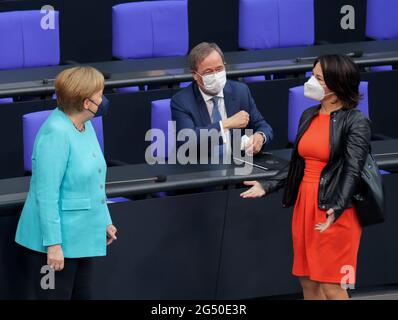 24 giugno 2021, Berlino: Il Cancelliere Angela Merkel (CDU, l) accoglie Annalena Baerbock (r), candidato alla cancelliera e alla leader federale di Bündnis 90/Die Grünen, e Armin Laschet, candidato della CDU al Cancelliere, leader federale della CDU e Presidente del Ministro della Renania settentrionale-Vestfalia, all'inizio della sessione del Bundestag tedesco. L'argomento è una dichiarazione del governo sul prossimo Consiglio dell'UE. Tra gli altri temi vi sono un dibattito sulla commissione d'inchiesta Amri, risoluzioni sull'estensione delle missioni delle forze armate tedesche in Kosovo e in Libano e votazioni su numerose leggi, tra cui il clima Foto Stock