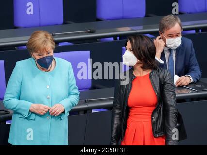 24 giugno 2021, Berlino: Il Cancelliere Angela Merkel (CDU, l) accoglie Annalena Baerbock (r), candidato alla cancelliera e alla leader federale di Bündnis 90/Die Grünen, e Armin Laschet, candidato della CDU al Cancelliere, leader federale della CDU e Presidente del Ministro della Renania settentrionale-Vestfalia, all'inizio della sessione del Bundestag tedesco. L'argomento è una dichiarazione del governo sul prossimo Consiglio dell'UE. Tra gli altri temi vi sono un dibattito sulla commissione d'inchiesta Amri, risoluzioni sull'estensione delle missioni delle forze armate tedesche in Kosovo e in Libano e votazioni su numerose leggi, tra cui il clima Foto Stock