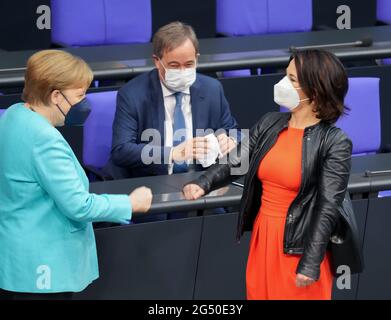 24 giugno 2021, Berlino: Il Cancelliere federale Angela Merkel (CDU, l) accoglie Annalena Baerbock (r), candidato alla cancelliera e alla guida federale di Bündnis 90/Die Grünen, e Armin Laschet, candidato della CDU al Cancelliere, leader federale della CDU e Presidente del Ministro della Renania settentrionale-Vestfalia, all'inizio della sessione del Bundestag tedesco. Tra gli altri temi figurano il dibattito sulla commissione d'inchiesta Amri, le risoluzioni sull'estensione delle missioni delle forze armate tedesche in Kosovo e in Libano e i voti su numerose leggi, tra cui la protezione del clima e la protezione degli insetti. Foto: Kay Nietfeld/dpa Foto Stock