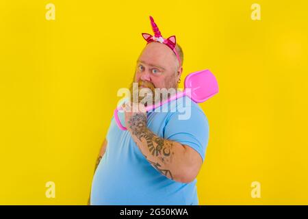 fat uomo con archetto gioco con paddle mare Foto Stock