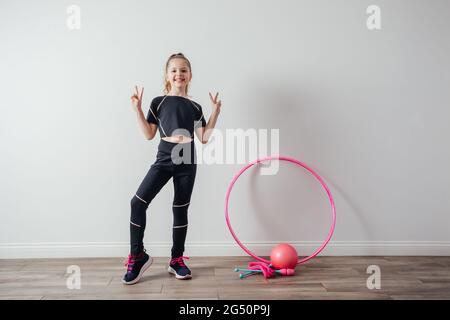 Giovane ragazza ginnastica professionale in posa con attrezzatura Foto Stock