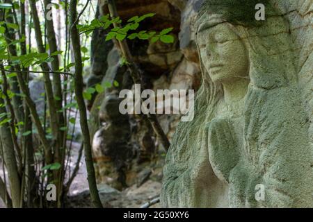 BOEMIA SETTENTRIONALE, CECHI, GIUGNO 06 2021, statua scolpita di un santo in preghiera in natura. Foto Stock