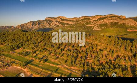 Veduta aerea dei dintorni del villaggio di Horta de Sant Joan e del massiccio dei porti di Els - Puertos in un tramonto estivo (Terra alta, Catalogna, Spagna) Foto Stock