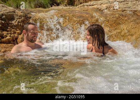 Coppia godendo di un bagno nella piscina naturale Olles nel fiume Canaletes, Horta de Sant Joan (Terra alta, Tarragona, Catalogna, Spagna) Foto Stock