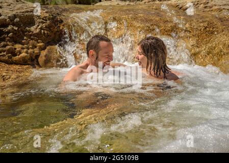 Coppia godendo di un bagno nella piscina naturale Olles nel fiume Canaletes, Horta de Sant Joan (Terra alta, Tarragona, Catalogna, Spagna) Foto Stock