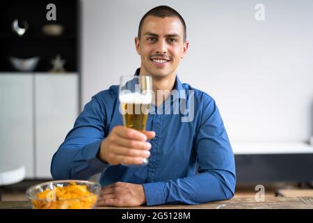 Uomo birra bere Video Conferenza Chat in Camera Foto Stock