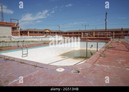 Clinton, Oklahoma - 6 maggio 2021: Piscina all'aperto sporca abbandonata presso le camere del Glancy Motel, ora abbandonate, lungo la storica strada US 66 Foto Stock