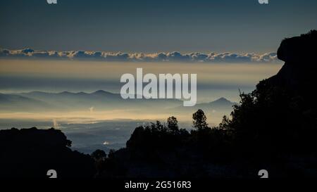 Alba sulle scogliere Fogueroses, sulla parete est di Montcau, guardando verso la pianura Vallès (Barcellona, Catalogna, Spagna) Foto Stock