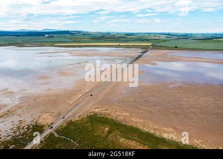 Veduta aerea della Lindisfarne, (Isola Santa) strada rialzata che la collega alla terraferma del Northumberland. Il Causeway si copre dal mare in alta marea Foto Stock