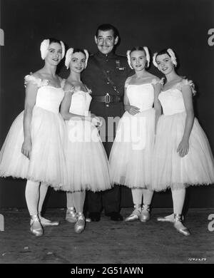 CLARK GABLE sul set candid con in primo piano ballerini di balletto ANNE ROWSE MONICA LEIGH HAZEL COWARD e CHRISTINA MARTIN alla MGM British Studios Boreham Wood durante le riprese di NEVER LET ME GO 1953 regista DELMER DAVES del romanzo come the Dawn di Paul Winterton produttore Clarence Brown Metro Goldwyn Mayer Foto Stock