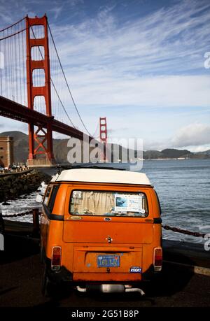Un pulmino utilizzato dai surfisti, parcheggiato di fronte al Golden Gate Bridge, San Francisco, California. Fort Point, sotto il ponte, è un popolare punto di surf. Foto Stock