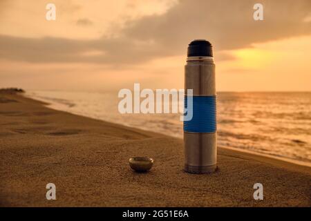 Pallone da vuoto e tazzina da tè su una spiaggia di sabbia Foto Stock
