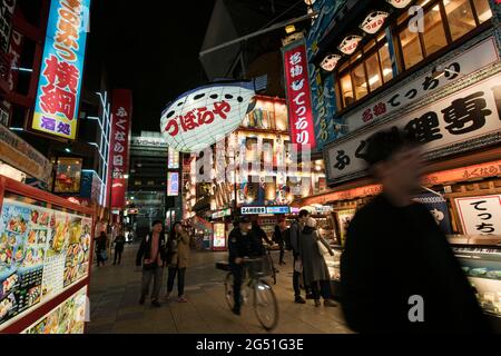Persone che camminano attraverso Shinsekai a Osaka, Giappone Foto Stock