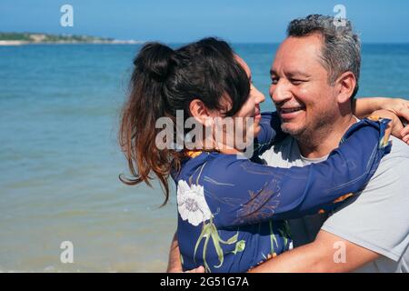 Coppia in piedi in acqua con l'orizzonte blu dietro di loro. Foto Stock