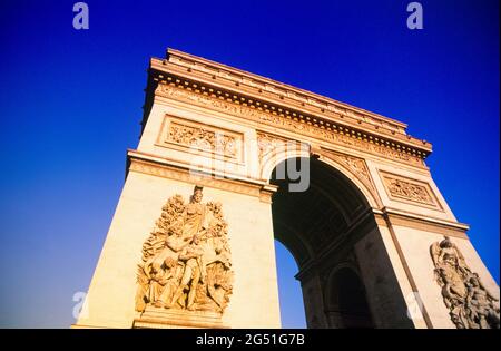 Foto ad angolo basso dell'Arco di Trionfo sotto il cielo blu chiaro, Parigi, Francia Foto Stock