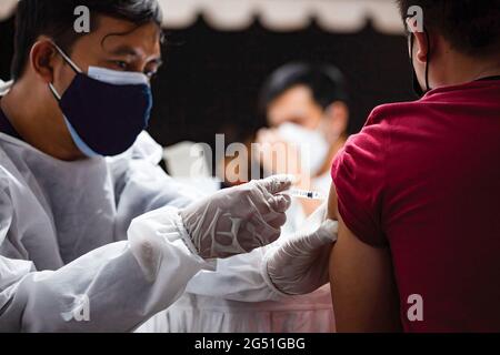 Giacarta, Indonesia. 24 Giugno 2021. Un operatore sanitario inietta il vaccino Sinovac ad un residente durante il servizio di vaccinazione mobile della covid 19. Il programma di vaccinazione di massa avviato dalla Polda Metro Jaya si svolgerà in 100 località e la sua attuazione durerà fino al 30 giugno 2021. L'aumento dei casi di Covid-19 in Indonesia ha nuovamente raggiunto un nuovo record, il che sta sollevando sempre più preoccupazioni per il fatto che la pandemia stia diventando fuori controllo in Indonesia. (Foto di Edy Susanto/SOPA Images/Sipa USA) Credit: Sipa USA/Alamy Live News Foto Stock