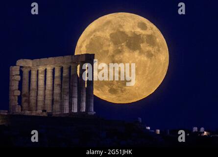 Atene, Grecia. 24 giugno 2021. La luna piena sorge sul Tempio di Poseidone a Capo Sounion, a circa 70 km a sud-est da Atene, Grecia. ©Elias Verdi/Alamy Live News Foto Stock