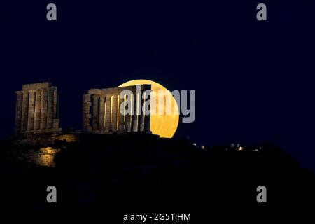 Atene, Grecia. 24 giugno 2021. La luna piena sorge sul Tempio di Poseidone a Capo Sounion, a circa 70 km a sud-est da Atene, Grecia. ©Elias Verdi/Alamy Live News Foto Stock