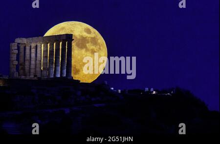 Atene, Grecia. 24 giugno 2021. La luna piena sorge sul Tempio di Poseidone a Capo Sounion, a circa 70 km a sud-est da Atene, Grecia. ©Elias Verdi/Alamy Live News Foto Stock
