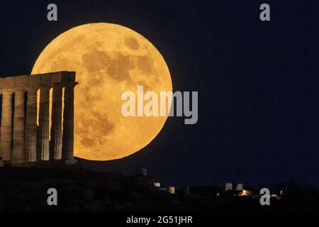 Atene, Grecia. 24 giugno 2021. La luna piena sorge sul Tempio di Poseidone a Capo Sounion, a circa 70 km a sud-est da Atene, Grecia. ©Elias Verdi/Alamy Live News Foto Stock