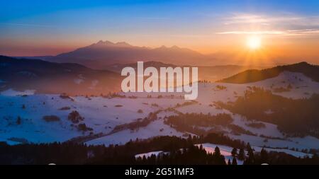 Nebbia in montagna Pieniny in inverno all'alba e Monti Tatra sullo sfondo, Malopolskie Voivodato, Polonia Foto Stock