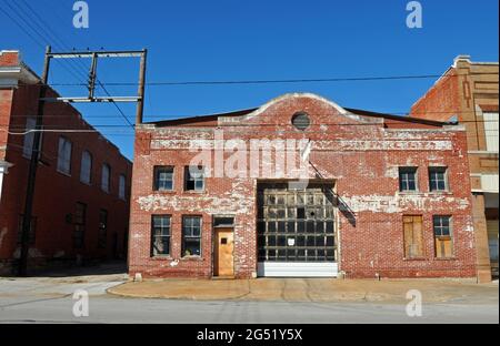 Questo storico edificio commerciale in mattoni, originariamente una stalla di livrea, ospitava un negozio di macchinari nella città di Sapulpa, Oklahoma, sulla Route 66. Foto Stock