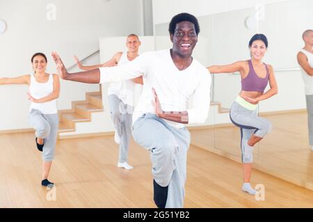 Allegro uomo afroamericano che pratica vigorosi movimenti di danza Foto Stock