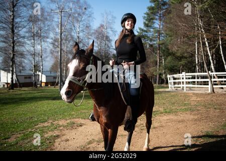 Ritratto di Femminile Jockey sicuro con Cavallo in piedi sul campo Foto Stock