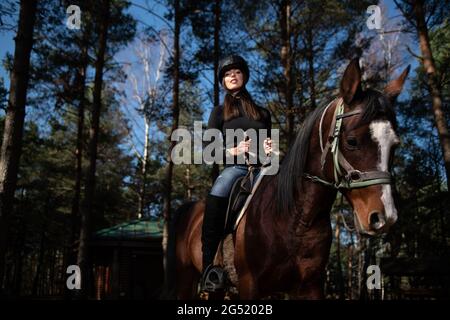 Ritratto di Femminile Jockey sicuro con Cavallo in piedi sul campo Foto Stock